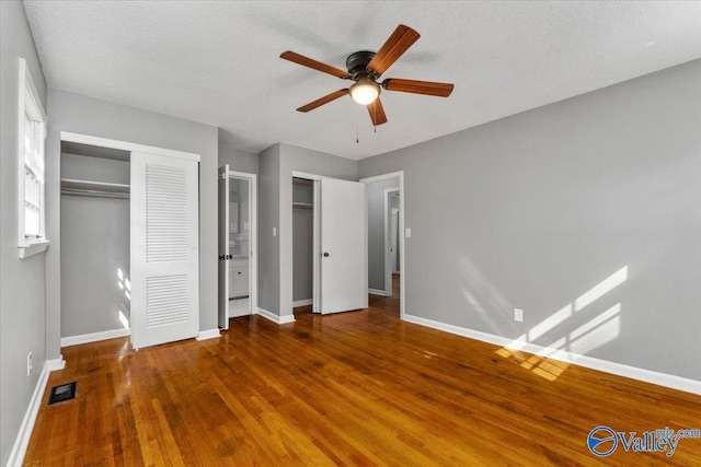 unfurnished bedroom with a textured ceiling, hardwood / wood-style flooring, and ceiling fan