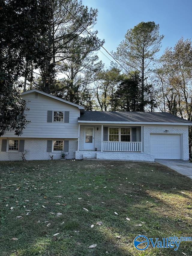 tri-level home featuring a garage and a front lawn