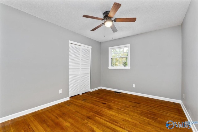 empty room featuring a textured ceiling, hardwood / wood-style flooring, and ceiling fan