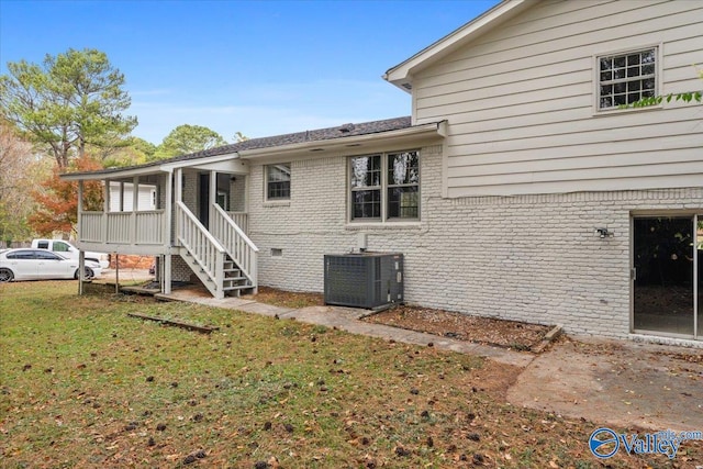 back of house featuring a lawn and central AC