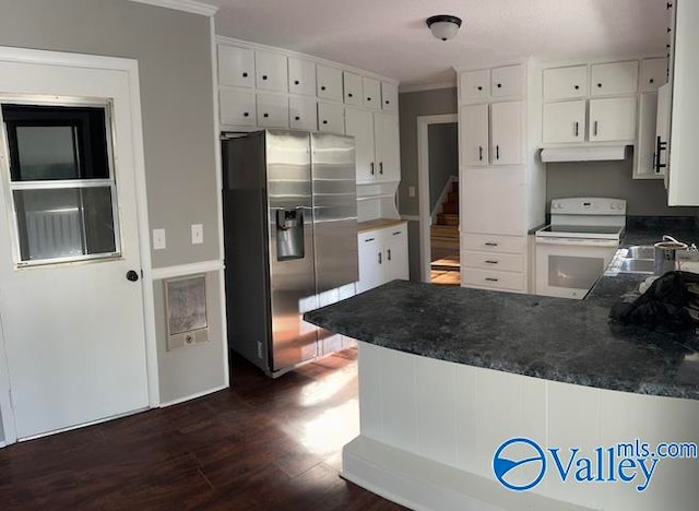 kitchen with white cabinets, stainless steel fridge, white electric stove, and kitchen peninsula