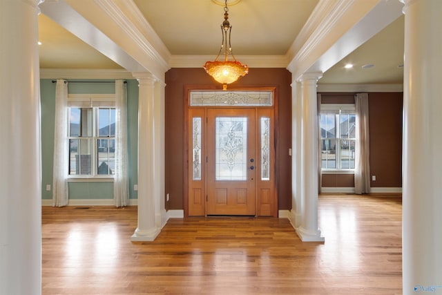 entryway with crown molding, light hardwood / wood-style flooring, and ornate columns