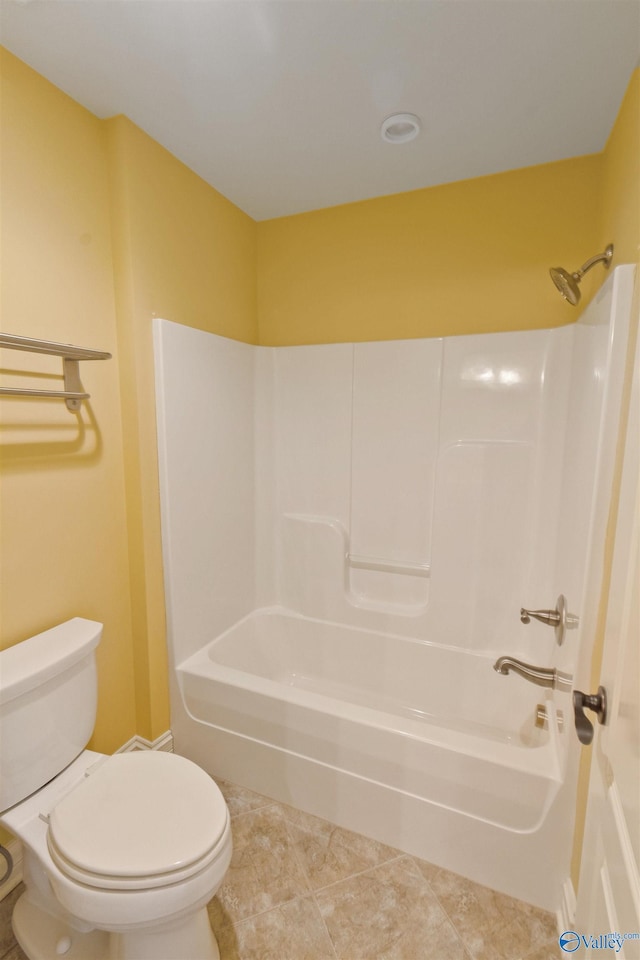 bathroom with tile patterned flooring, shower / bathing tub combination, and toilet