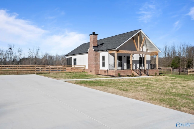 view of front of house featuring a chimney, crawl space, covered porch, fence, and a front lawn