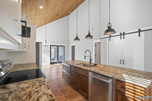 kitchen with wooden ceiling, stainless steel appliances, a sink, dark wood finished floors, and pendant lighting