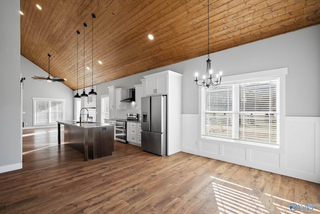 kitchen featuring dark wood finished floors, wall chimney exhaust hood, wood ceiling, stainless steel appliances, and a sink