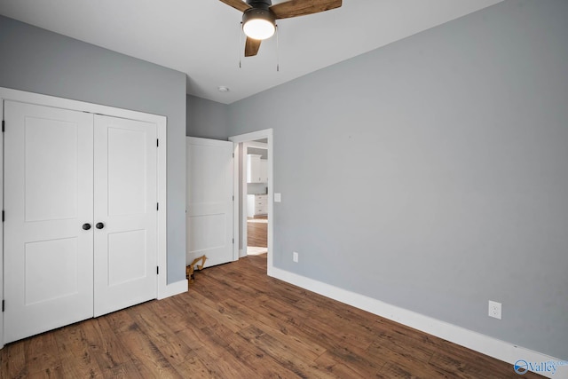 unfurnished bedroom with a ceiling fan, a closet, baseboards, and wood finished floors