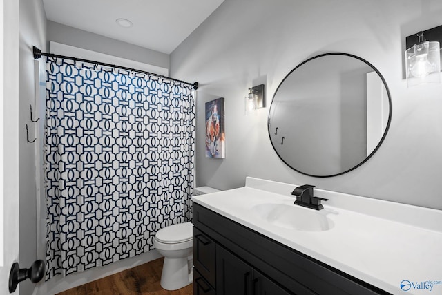 bathroom with wood finished floors, curtained shower, vanity, and toilet