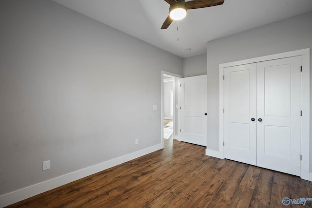 unfurnished bedroom featuring ceiling fan, a closet, wood finished floors, and baseboards