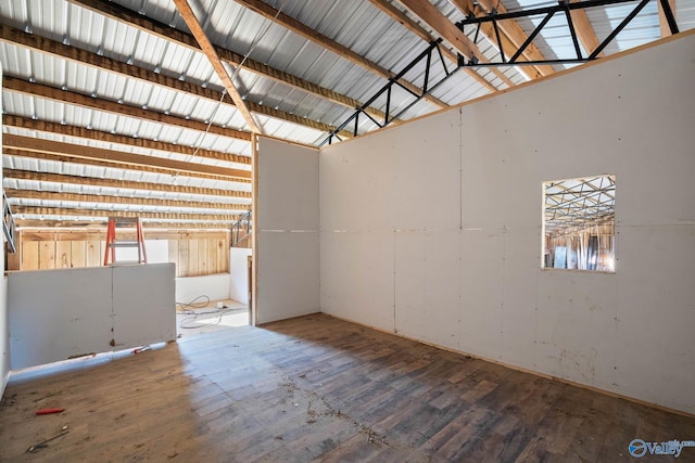 unfurnished room featuring metal wall and wood finished floors