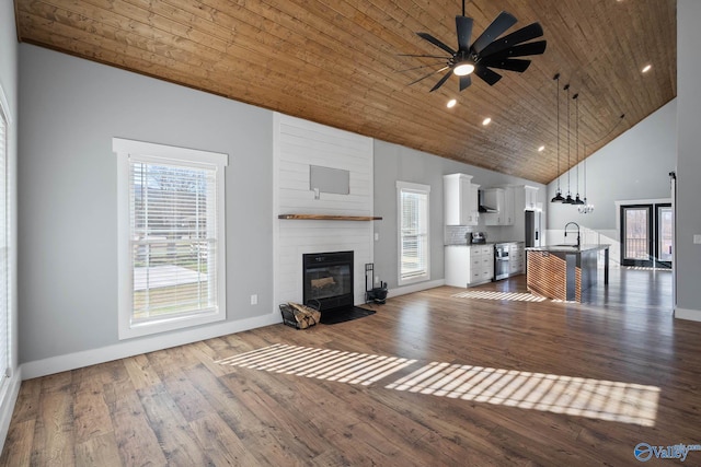 unfurnished living room with high vaulted ceiling, a sink, wood ceiling, a ceiling fan, and dark wood-style floors