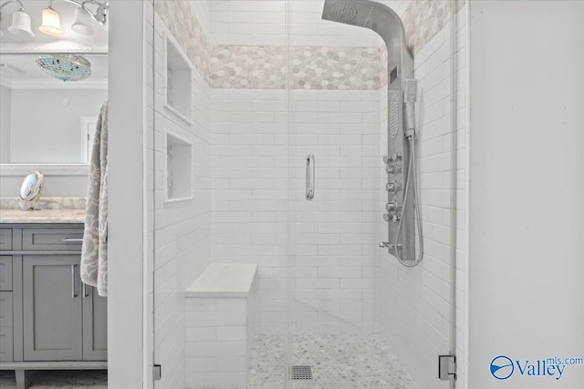bathroom with vanity, a shower stall, and ornamental molding