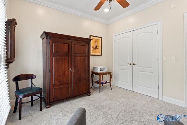 living area with light carpet, baseboards, ornamental molding, and ceiling fan