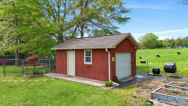 view of outdoor structure with fence, a vegetable garden, and an outdoor structure