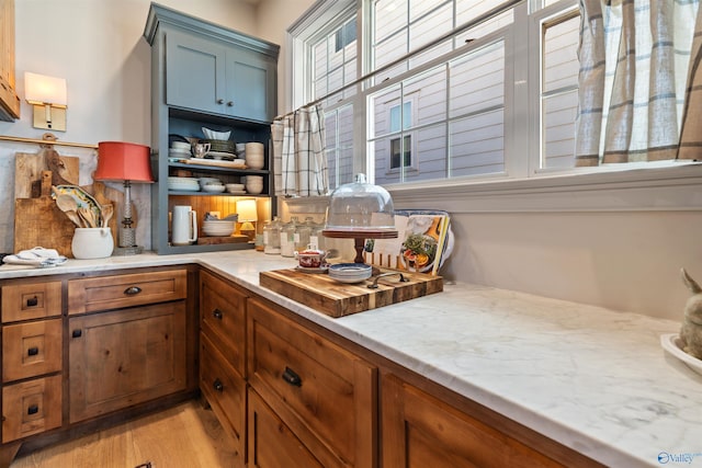 kitchen featuring light stone countertops and light wood-type flooring