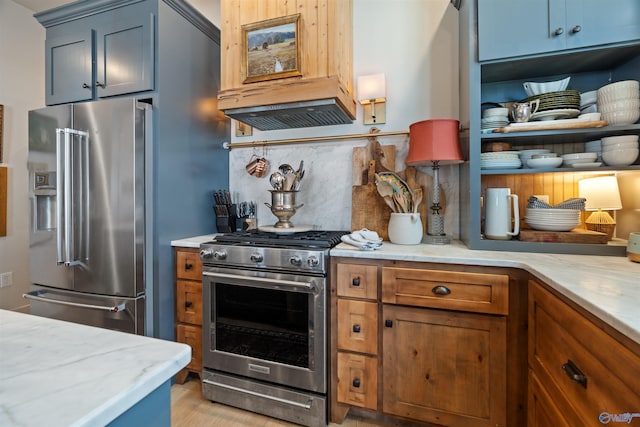 kitchen featuring premium appliances, custom exhaust hood, light stone countertops, and decorative backsplash