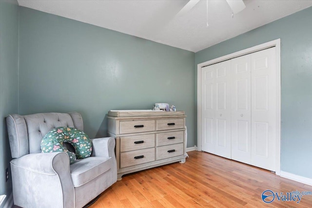 living area featuring light wood-style flooring, baseboards, and ceiling fan