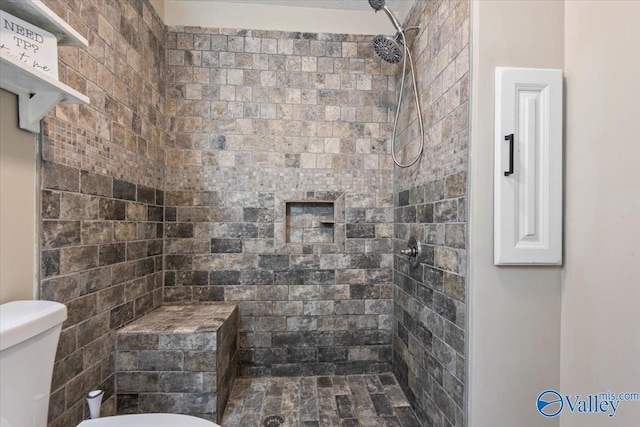 full bathroom with toilet and a tile shower