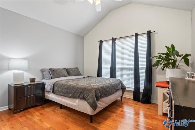 bedroom with baseboards, light wood-type flooring, a ceiling fan, and vaulted ceiling