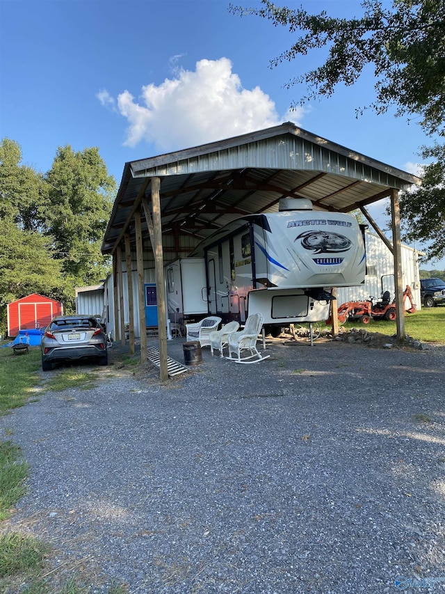 view of vehicle parking featuring gravel driveway and a detached carport