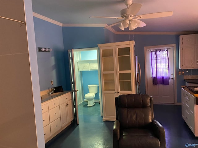 interior space with crown molding, white cabinets, ceiling fan, stainless steel fridge, and sink