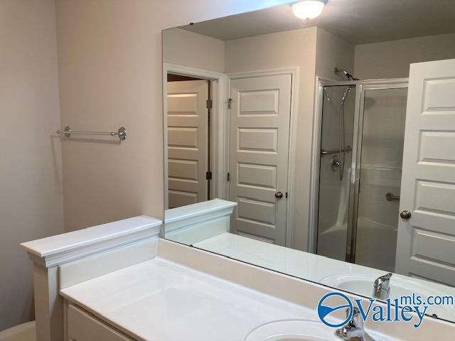 bathroom featuring a shower stall and vanity