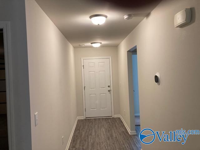 doorway to outside with dark wood-type flooring and baseboards