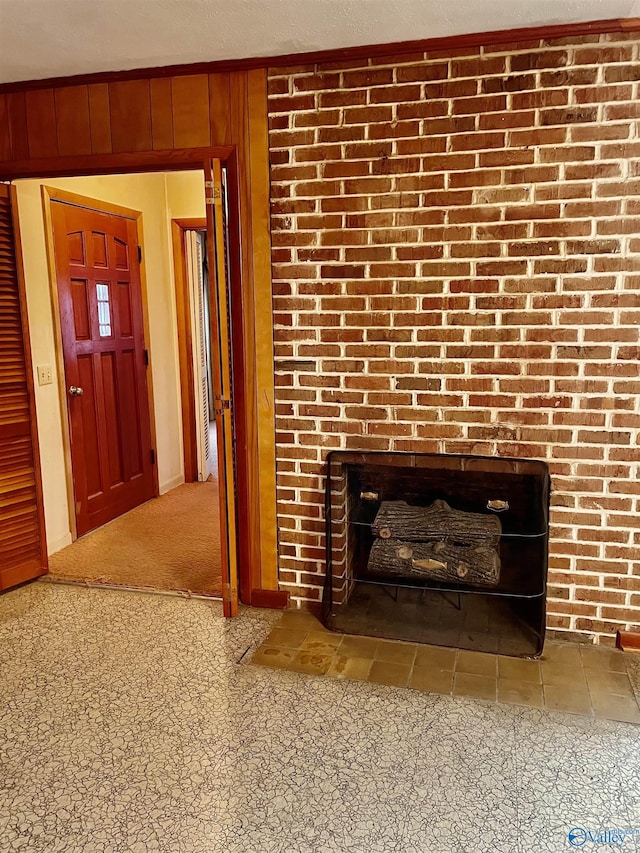 details featuring wood walls, carpet floors, and a brick fireplace