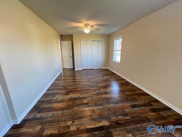 unfurnished bedroom featuring dark hardwood / wood-style floors, a closet, and ceiling fan