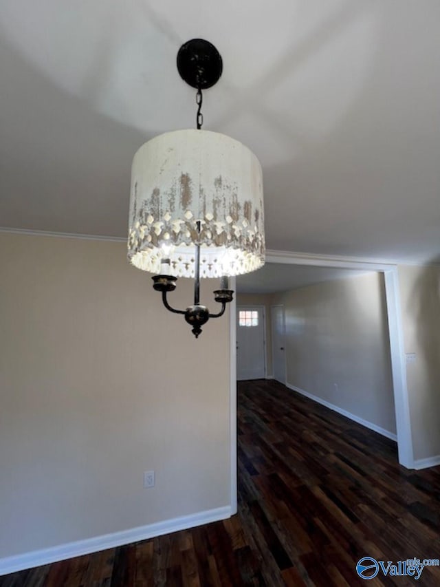 unfurnished dining area with ornamental molding and dark hardwood / wood-style floors