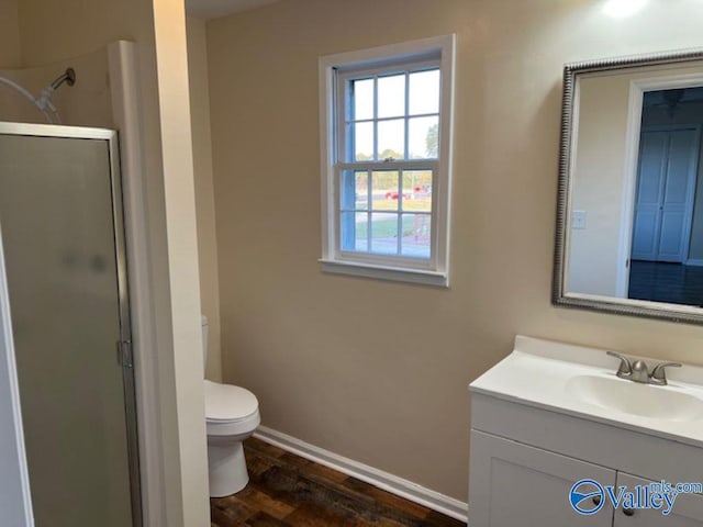 bathroom featuring vanity, toilet, hardwood / wood-style flooring, and a shower