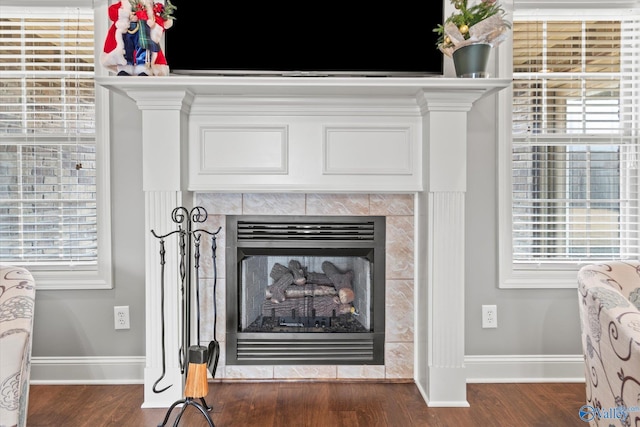 interior details featuring a tile fireplace and hardwood / wood-style floors