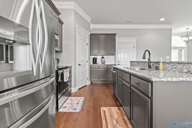 kitchen featuring crown molding, stainless steel appliances, dark hardwood / wood-style floors, and an inviting chandelier