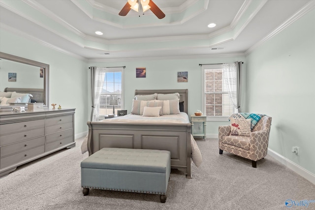 bedroom with a tray ceiling, crown molding, ceiling fan, and light colored carpet