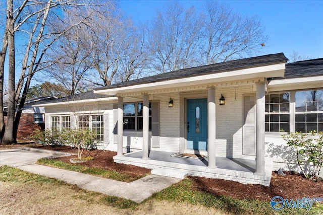 view of front of home with brick siding and a porch