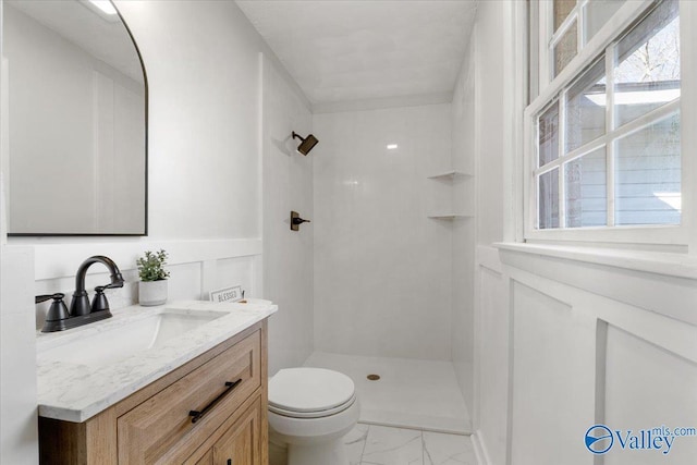 full bathroom featuring marble finish floor, toilet, a shower stall, and vanity