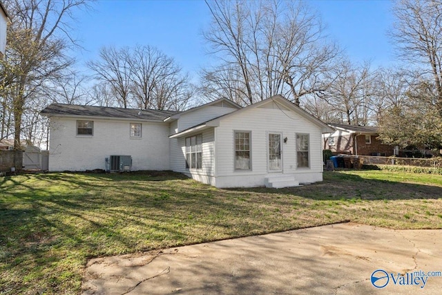 exterior space featuring a lawn, fence, and central AC unit