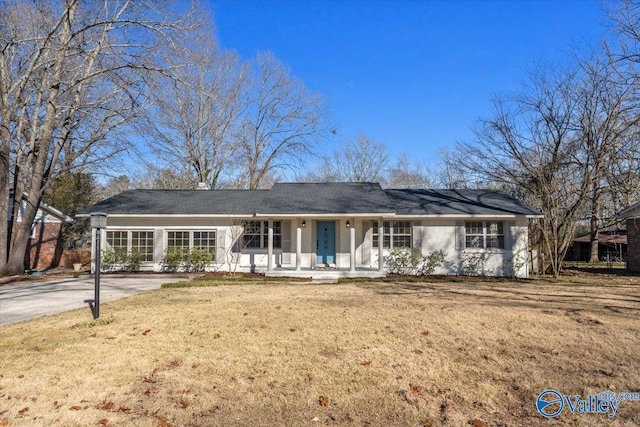 rear view of property with driveway, a porch, and a yard