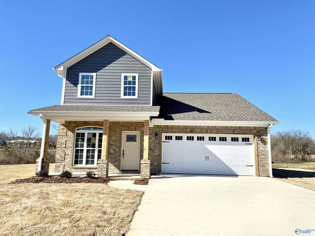 100 James Bowie Dr, Athens, AL 35611 - view of front of property with driveway, an attached garage, a porch, a shingled roof, and brick siding