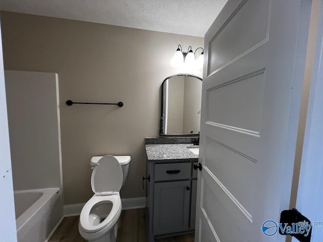 100 James Bowie Dr, Athens, AL 35611 - full bathroom featuring vanity, toilet, baseboards, a tub to relax in, and a textured ceiling