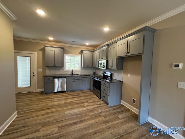 100 James Bowie Dr, Athens, AL 35611 - kitchen with appliances with stainless steel finishes, gray cabinets, dark countertops, a sink, and crown molding