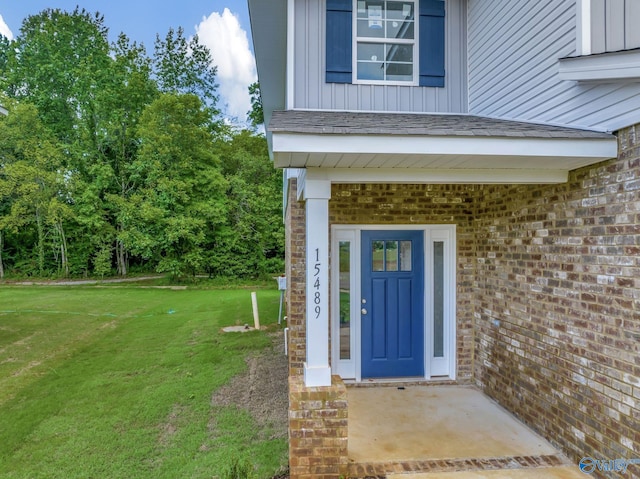 entrance to property featuring a lawn