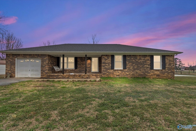 ranch-style house featuring a garage and a lawn