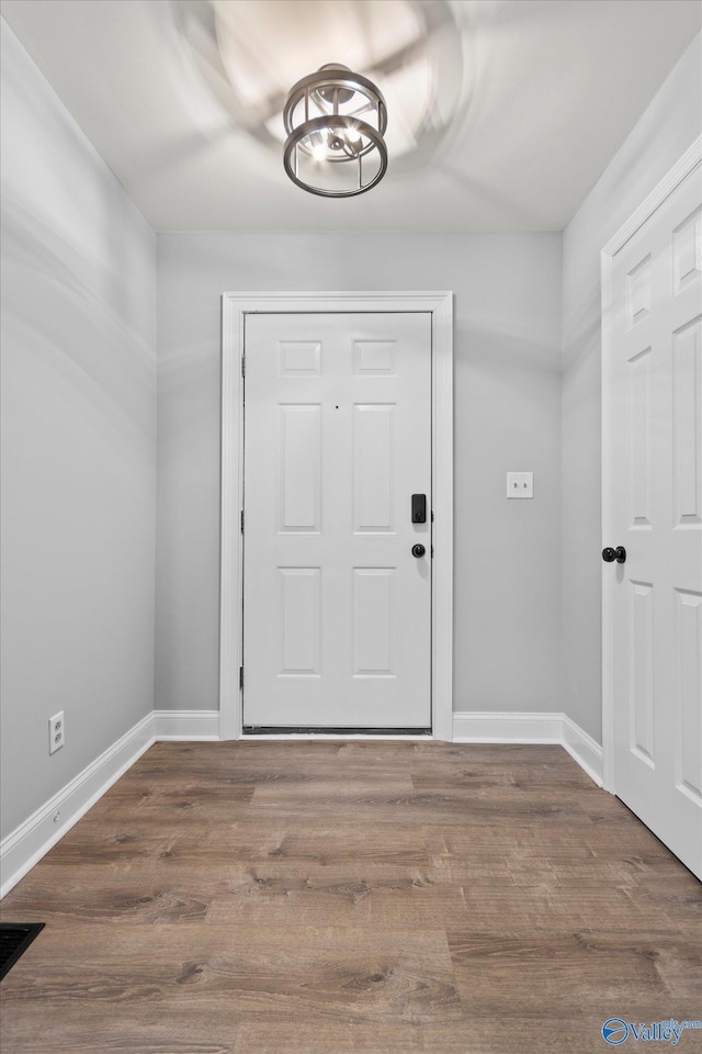 foyer featuring hardwood / wood-style floors and a chandelier