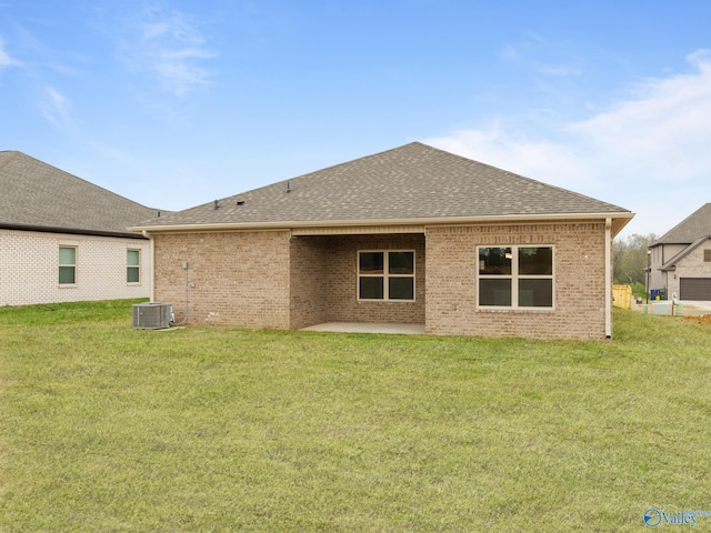 back of property with a lawn, a patio, and central AC