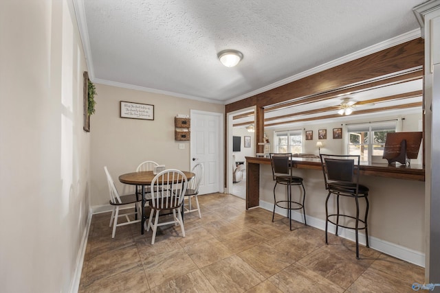 dining area with crown molding, baseboards, and a textured ceiling