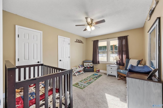 bedroom featuring a textured ceiling, ceiling fan, baseboards, and carpet