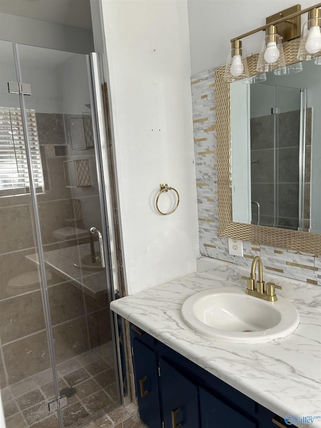 bathroom with vanity, an enclosed shower, and backsplash