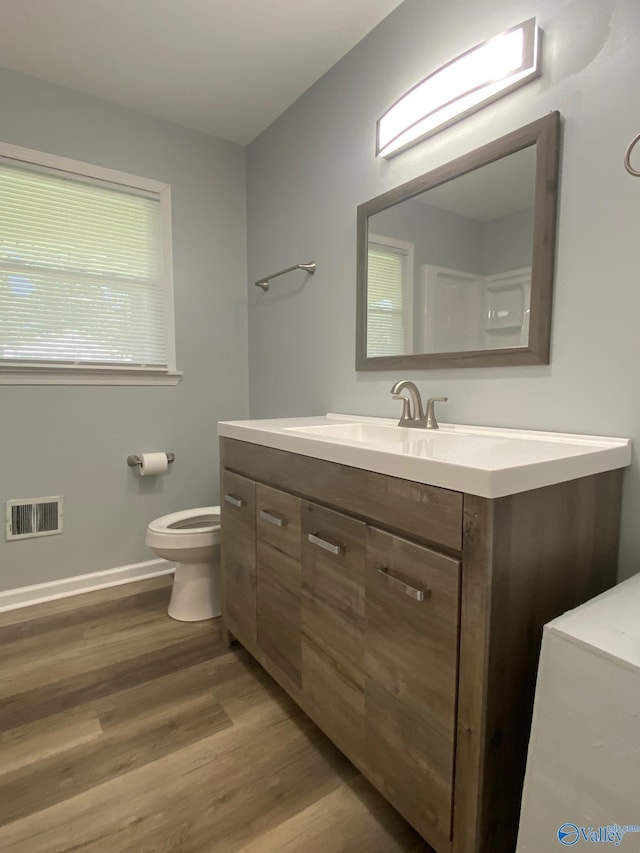 bathroom featuring hardwood / wood-style flooring, toilet, and vanity