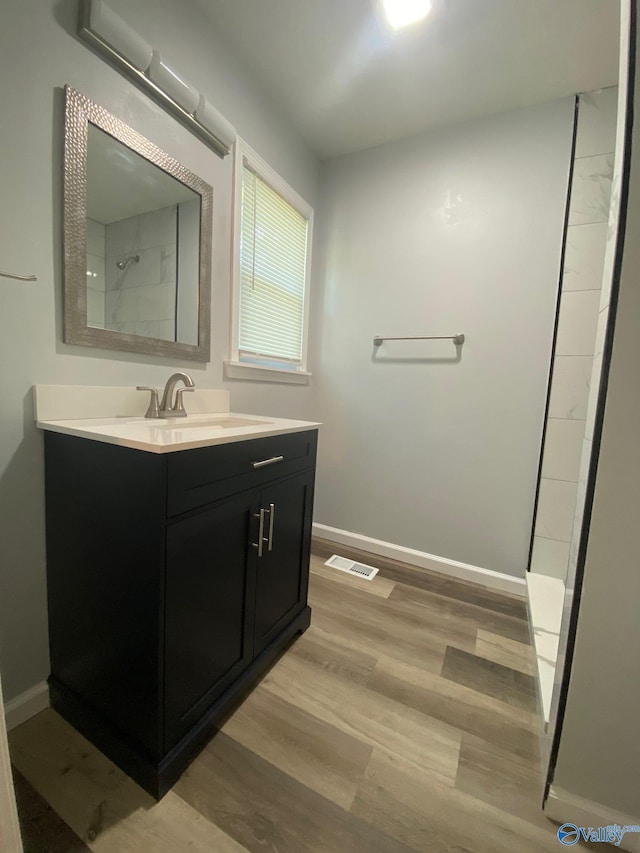 bathroom featuring vanity, hardwood / wood-style floors, and walk in shower